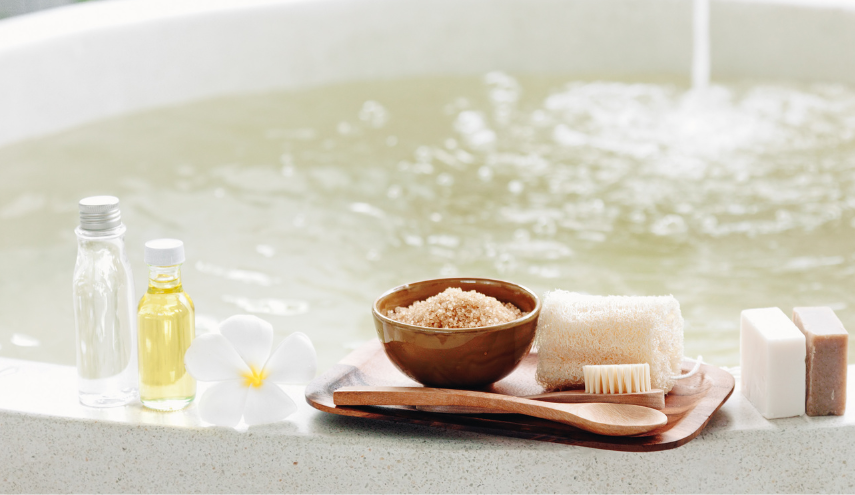 wanna napełniona wodą na rancie kosmetyki i sól magnezowa w brązowek misce